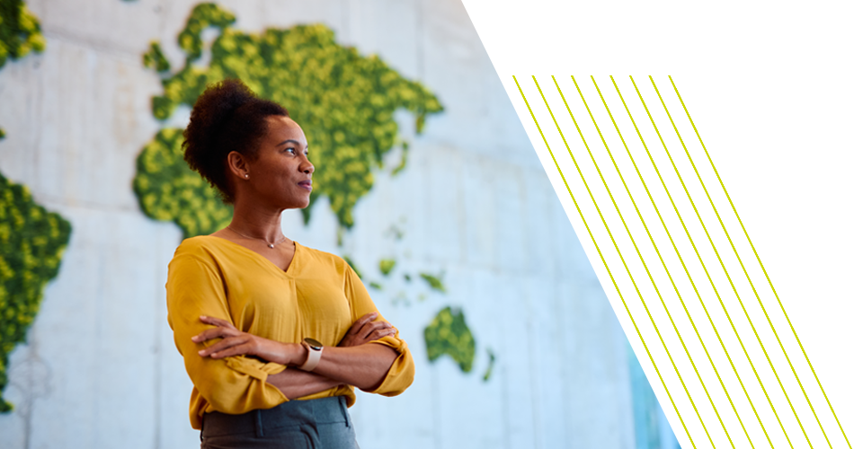 Woman stands in from of world map mural.